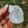 Una mano sosteniendo un colgante de jade.