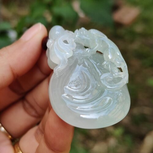 Una mano sosteniendo un colgante de jade.