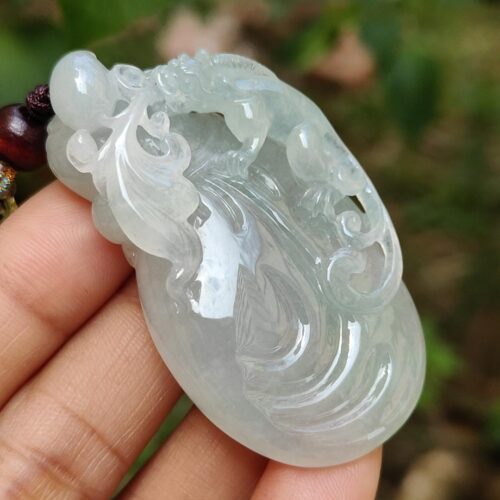 Una mano sosteniendo un colgante de jade.