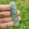 a hand holding a jade bird