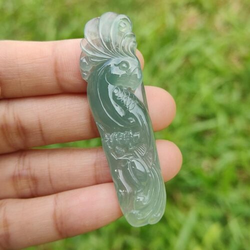 a hand holding a jade bird