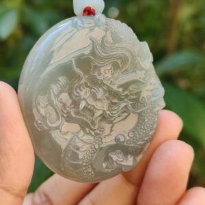 Una mano sosteniendo un colgante de jade.