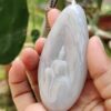 a hand holding a white stone