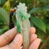 Una mano sosteniendo un colgante de jade.