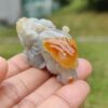 Una mano sosteniendo un pequeño animal de piedra.