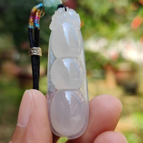 Una mano sosteniendo un colgante de jade.