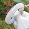 một bàn tay cầm một chiếc nhẫn màu trắng