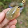 Una mano sosteniendo un colgante de jade.