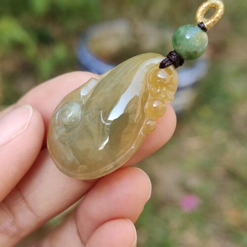 Una mano sosteniendo un colgante de jade.