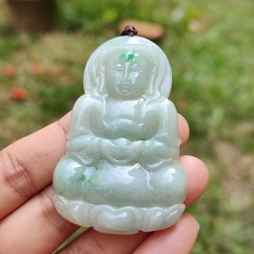a hand holding a jade buddha