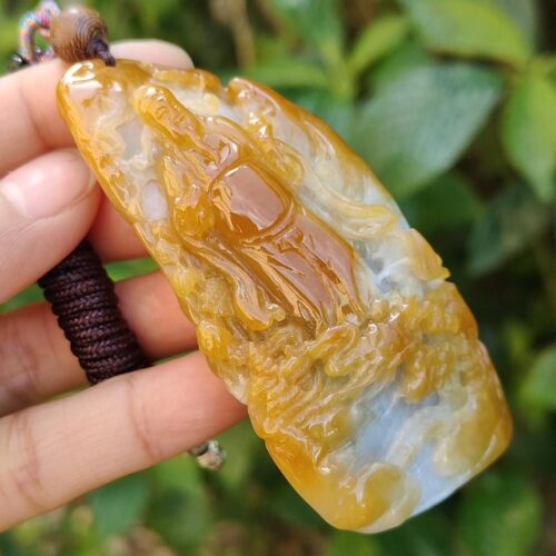 a hand holding a stone pendant