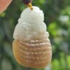 une main tenant un pendentif en jade
