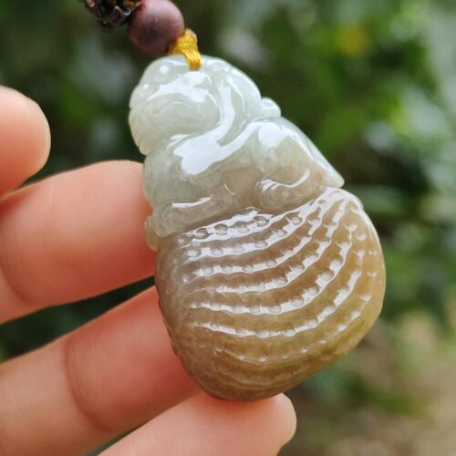 une main tenant un pendentif en jade