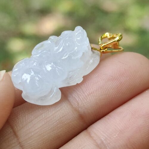 a hand holding a white jade pendant