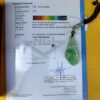 f3b0afb012e904c261d2c177553c9ed9 a green jade pendant on a blue and white paper