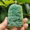 a hand holding a jade pendant