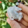 a hand holding a white horse pendant