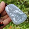 Una mano sosteniendo un colgante de jade.