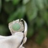 a silver ring with a green stone in it
