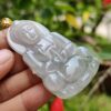 a hand holding a jade pendant