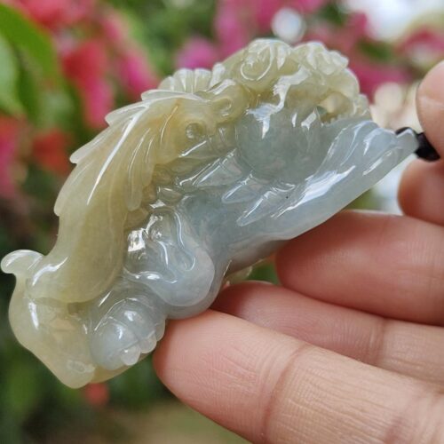 a hand holding a jade sculpture