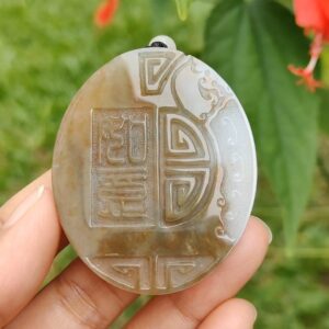 Una mano sosteniendo un colgante de piedra.