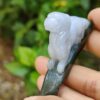 a hand holding a small stone sculpture