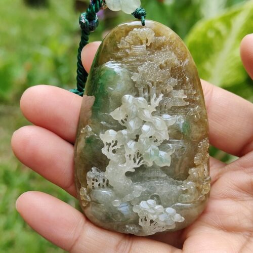 a hand holding a stone pendant