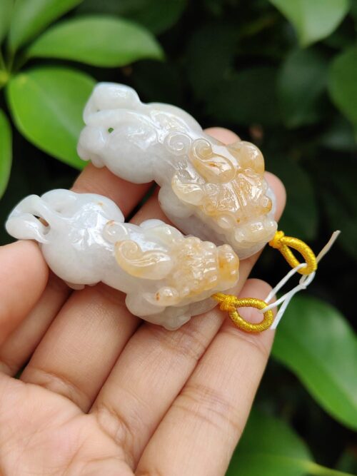 a hand holding a small white and yellow stone