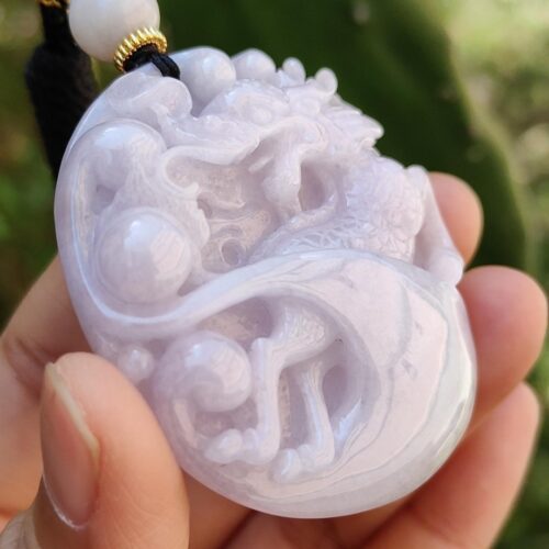 Una mano sosteniendo un colgante de jade.