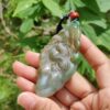 Una mano sosteniendo un colgante de jade.
