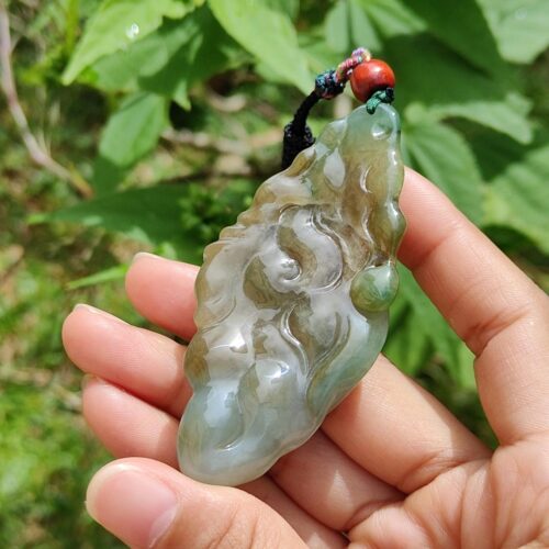 Una mano sosteniendo un colgante de jade.