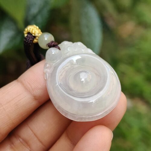 Una mano sosteniendo un colgante de jade.