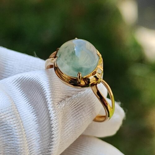 a ring with a green stone in a gold ring