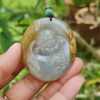 a hand holding a jade pendant