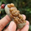 Una mano sosteniendo un colgante de jade.
