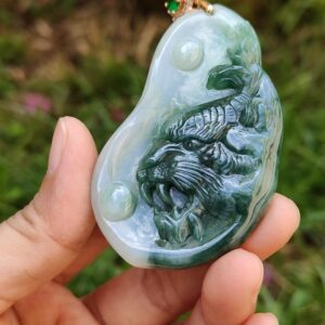 Una mano sosteniendo un colgante de jade.