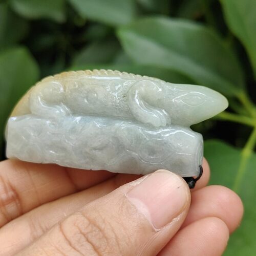 a hand holding a jade lizard