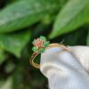 a gold ring with green stones on it
