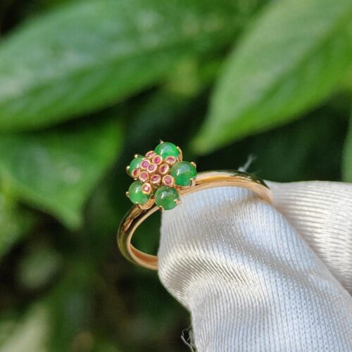 a gold ring with green stones on it