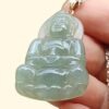 a hand holding a jade pendant