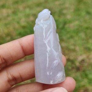 एक हाथ में जेड की मूर्ति पकड़े हुए