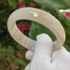 a hand wearing a glove holding a white ring