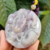Una mano sosteniendo un colgante de jade.