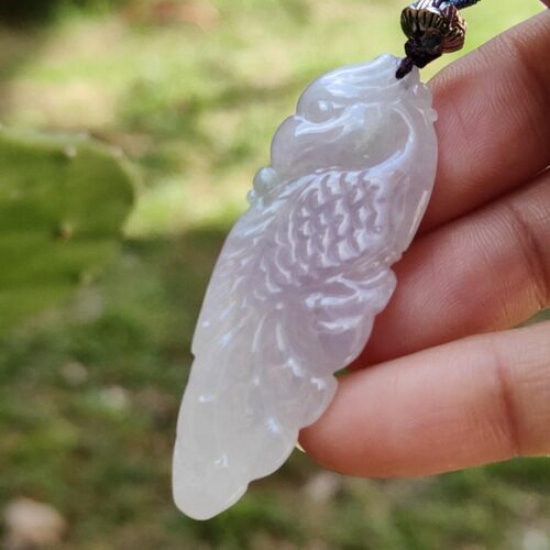 Una mano sosteniendo un colgante de piedra blanca.