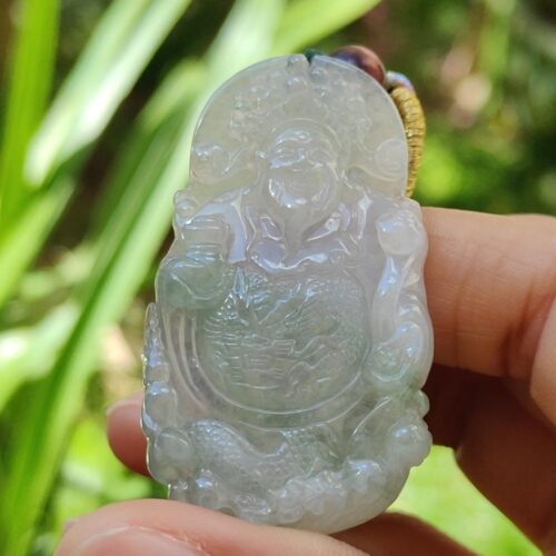 a hand holding a jade pendant