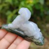a hand holding a small stone statue