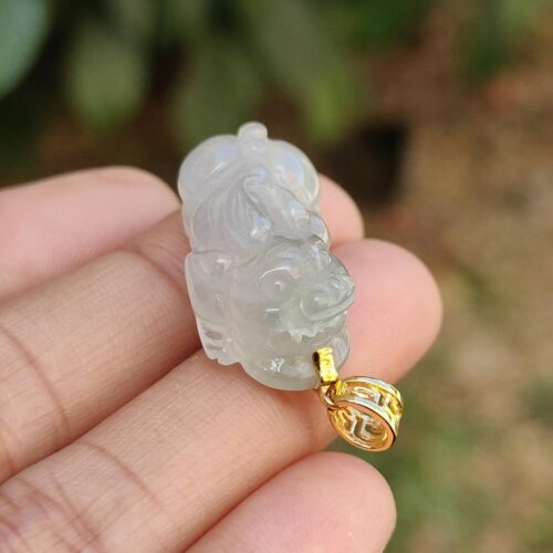 Una mano sosteniendo un colgante de jade.