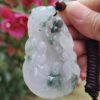 Una mano sosteniendo un colgante de jade.