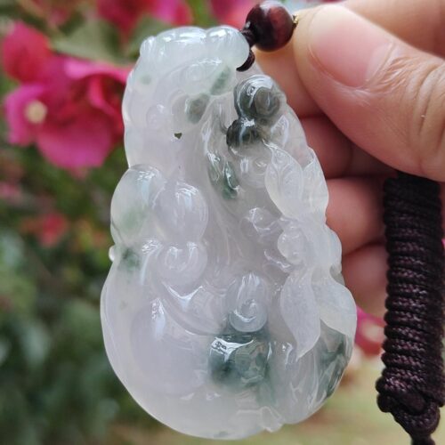 Una mano sosteniendo un colgante de jade.
